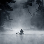 Одинокий рыбак, плывущий на лодке с одним веслом, среди о...