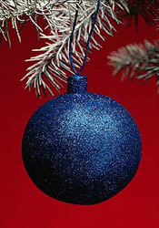 Синий новогодний шарик на красном фоне