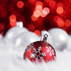 Красный новогодний шар со снежинкой лежит в белом меху