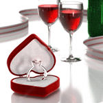 Кольцо в коробочке-сердечке и два бокала с красным вином ...