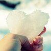 Кусок снега в форме сердечка в руке