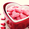 Мармеладные конфеты в виде сердец лежат в красной коробке