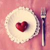 Красное сердце на тарелке и вилка