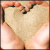 Сердце из песка в руках