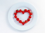 На тарелке выложенно сердце с клубники