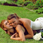  <b>Счастливые</b> невеста с женихом обнимаются, лёжа на траве 