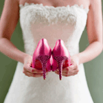 Невеста держит розовые туфли в руках