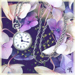 Часы на цепочке лежат среди кремовых и фиолетовых цветов
