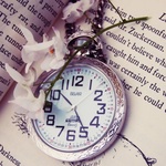 Старинные часы лежат на книге
