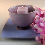 Свеча в чаше стоит возле цветов