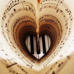  <b>Листочки</b> нотной тетради сложены в форме сердечка на фоне ... 