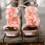  <b>Босоножки</b> с розовыми цветами стоят на деревянной скамейке... 