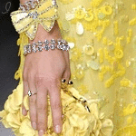  <b>Женская</b> рука с браслетами и кольцом, держит желтый клатч 
