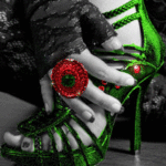 Рука с большим красным кольцом держится за зеленую туфлю,...