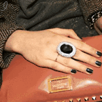 Женская рука с кольцом, придерживающая сумку