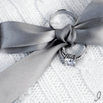Кольца и серый бантик на белом свитере