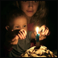 Мама с ребенком смотрят на свечу в торте